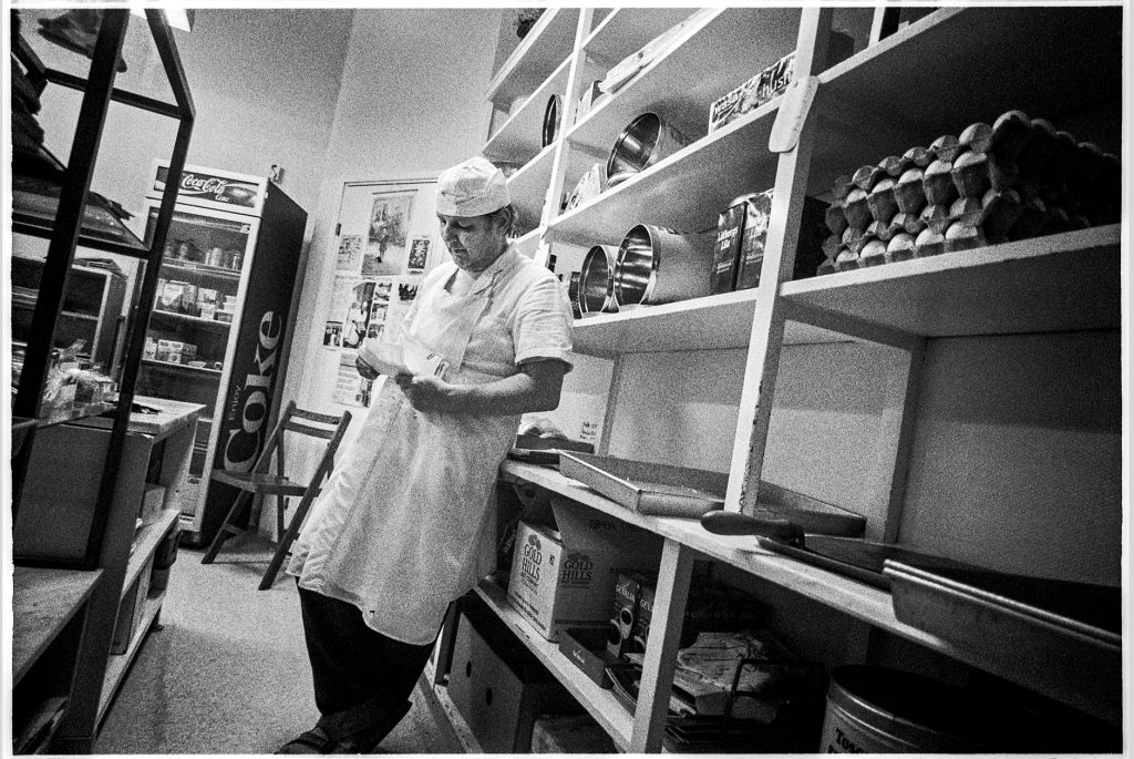 Black and white documentary picture of a baker in the store